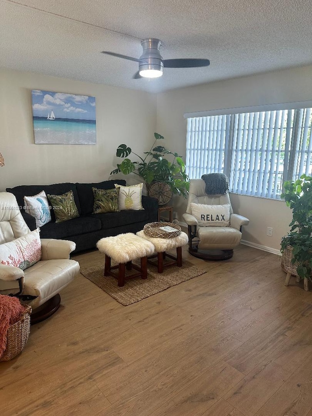 living room featuring a textured ceiling, ceiling fan, and hardwood / wood-style flooring