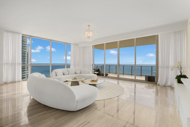 living room featuring an inviting chandelier, a wall of windows, plenty of natural light, and a water view