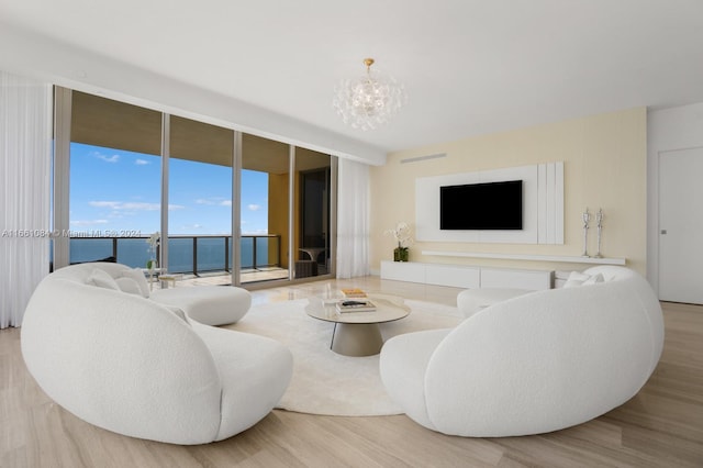 living room featuring light hardwood / wood-style floors, floor to ceiling windows, and a chandelier