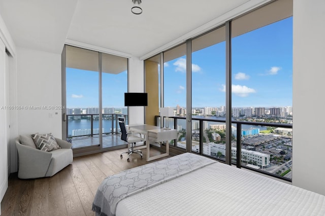 bedroom featuring a wall of windows and hardwood / wood-style floors