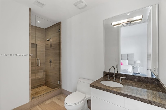 bathroom featuring vanity, toilet, and a shower with door