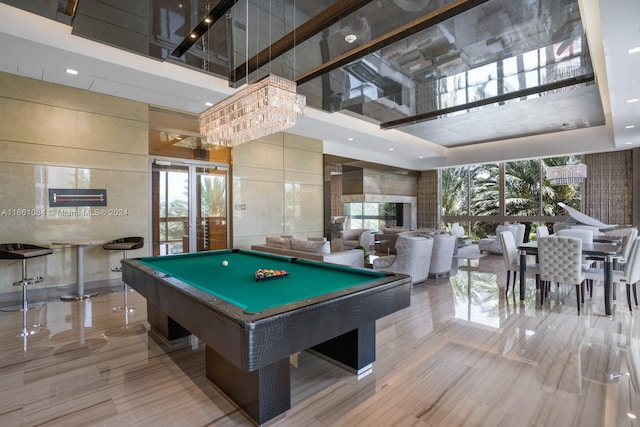 recreation room featuring a high ceiling, pool table, a fireplace, and a healthy amount of sunlight