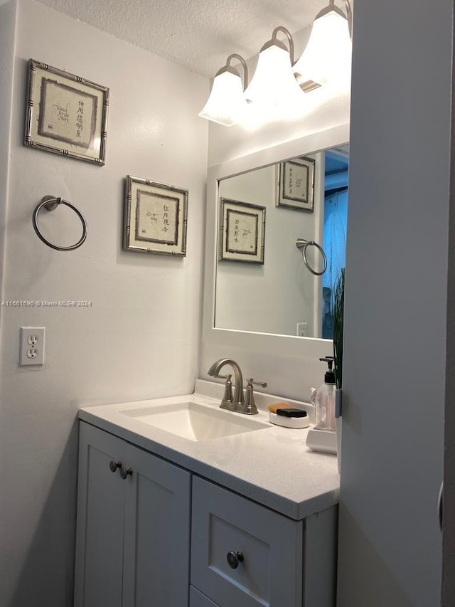 bathroom featuring a textured ceiling and vanity