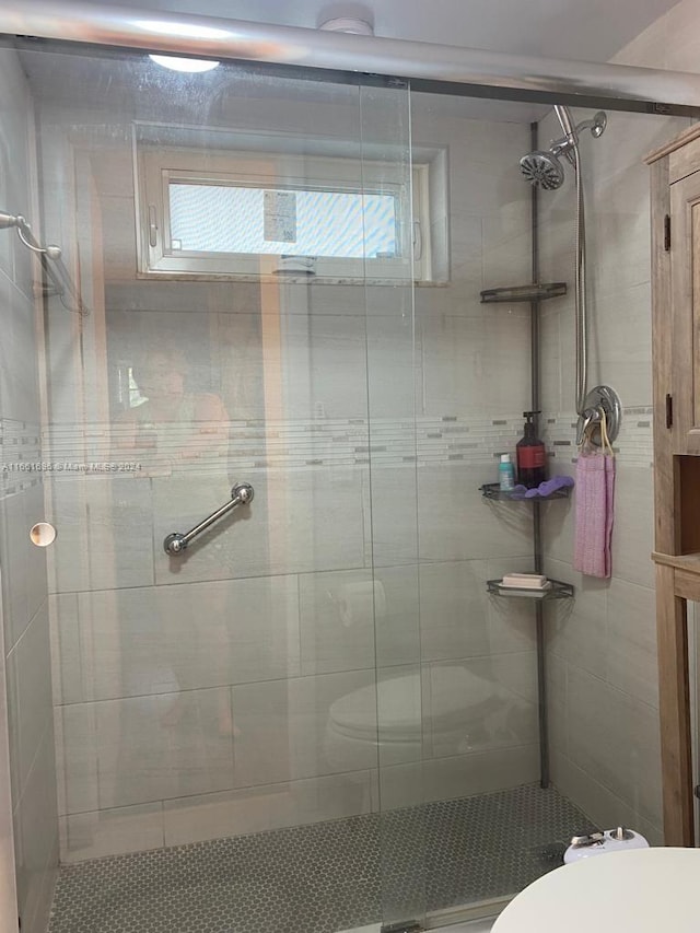 bathroom with toilet and an enclosed shower