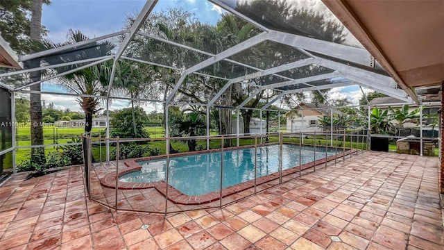 view of swimming pool featuring glass enclosure and a patio