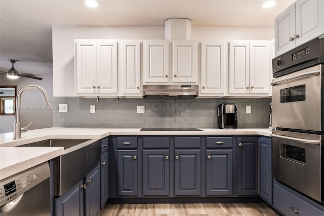 kitchen with ceiling fan, light hardwood / wood-style flooring, white cabinetry, stainless steel appliances, and decorative backsplash