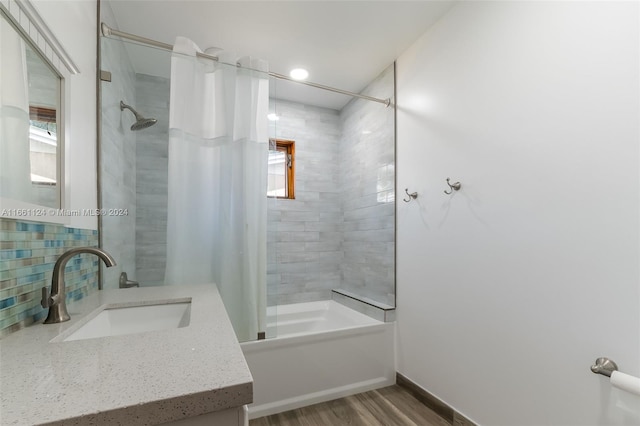 bathroom with wood-type flooring, shower / bath combination with curtain, vanity, and backsplash