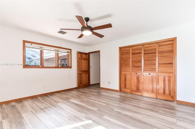 unfurnished bedroom featuring a closet, light hardwood / wood-style floors, and ceiling fan