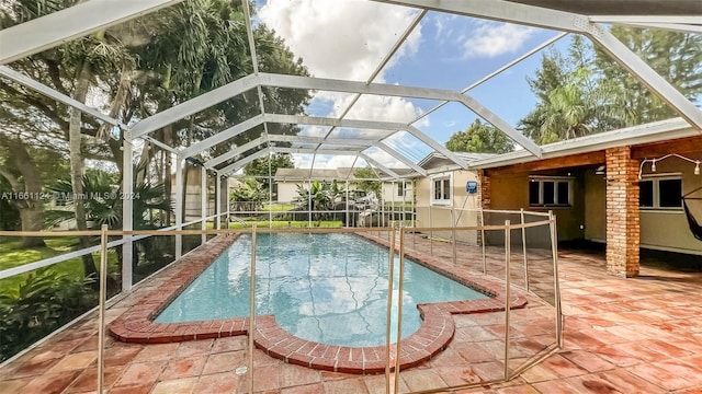 view of swimming pool featuring glass enclosure and a patio area