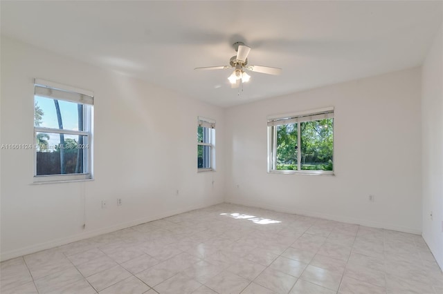 empty room with ceiling fan and a wealth of natural light