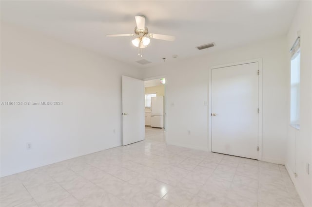 empty room with ceiling fan and plenty of natural light