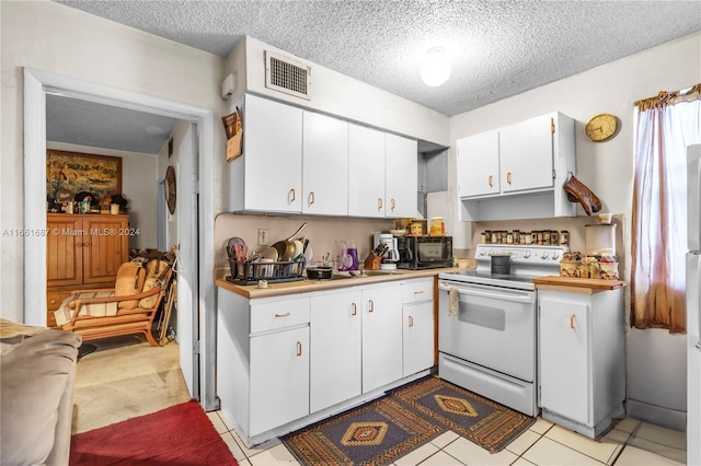 kitchen featuring light tile patterned floors, white cabinets, a textured ceiling, and white electric stove