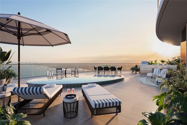 pool at dusk featuring outdoor lounge area and a deck with water view