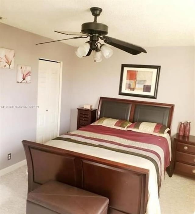 carpeted bedroom with ceiling fan and a closet