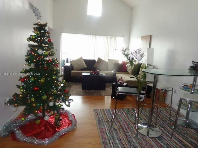 living room featuring light wood-type flooring and high vaulted ceiling