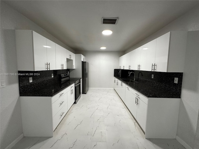 kitchen with appliances with stainless steel finishes, white cabinetry, and sink