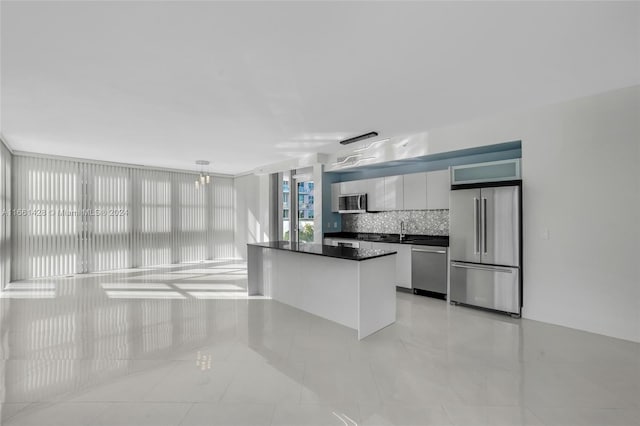 kitchen with sink, pendant lighting, decorative backsplash, light tile patterned floors, and appliances with stainless steel finishes