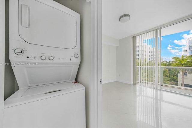 washroom with light tile patterned floors and stacked washer and clothes dryer