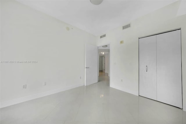 unfurnished bedroom featuring light tile patterned floors and a closet