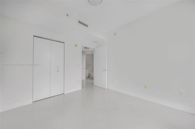 unfurnished bedroom with a closet and light tile patterned floors