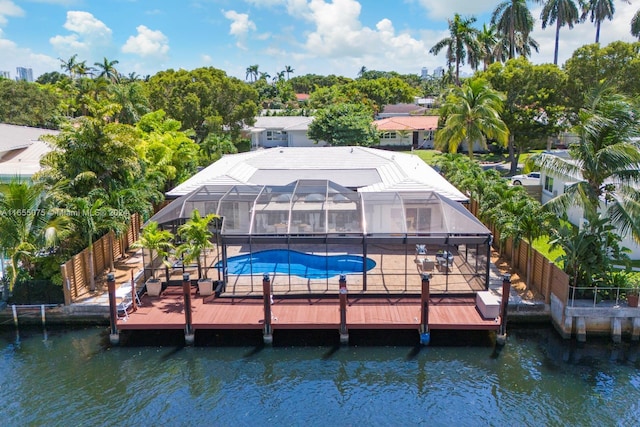 rear view of house with a water view and glass enclosure