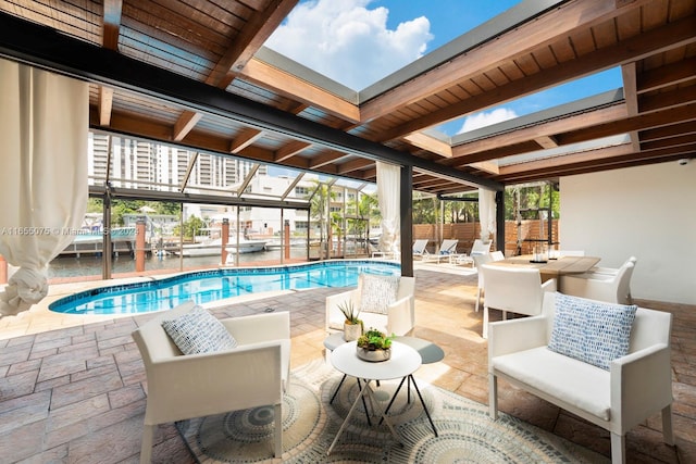 view of pool featuring a water view and a patio