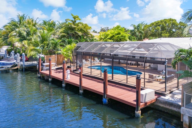 view of dock with a lanai, a patio area, and a water view