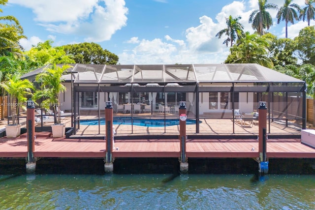 view of dock featuring a fenced in pool, glass enclosure, a patio area, and a water view