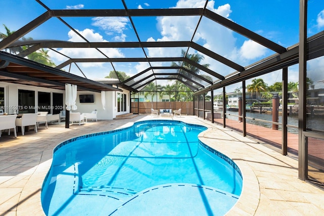 view of swimming pool featuring a lanai and a patio