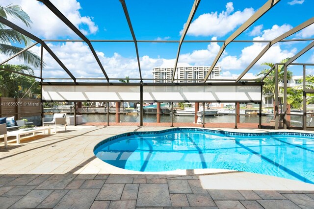 view of pool featuring a lanai, a patio area, and a water view