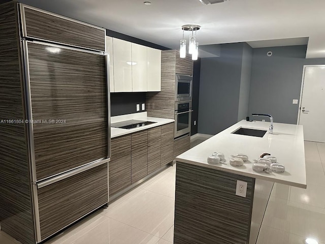 kitchen with white cabinets, light tile patterned floors, sink, decorative light fixtures, and appliances with stainless steel finishes