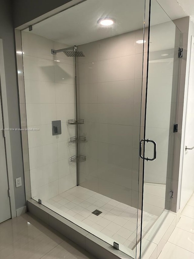 bathroom with tile patterned flooring and a shower with door