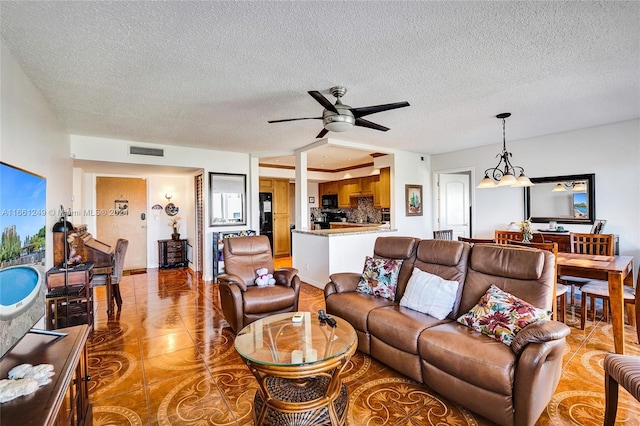 living room featuring ceiling fan, light tile patterned floors, and a textured ceiling