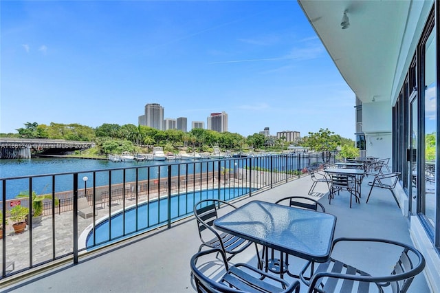 balcony featuring a water view and a patio area