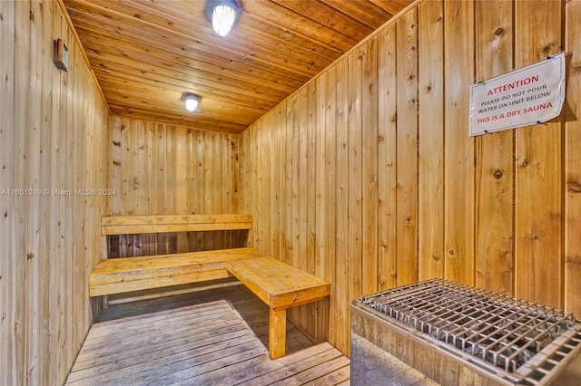 view of sauna featuring wood-type flooring, wooden walls, and wooden ceiling