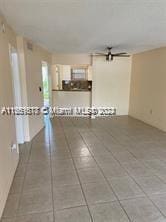 unfurnished living room featuring ceiling fan and tile patterned floors