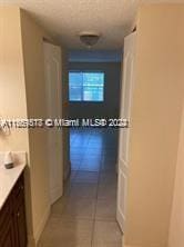 hall with light tile patterned floors