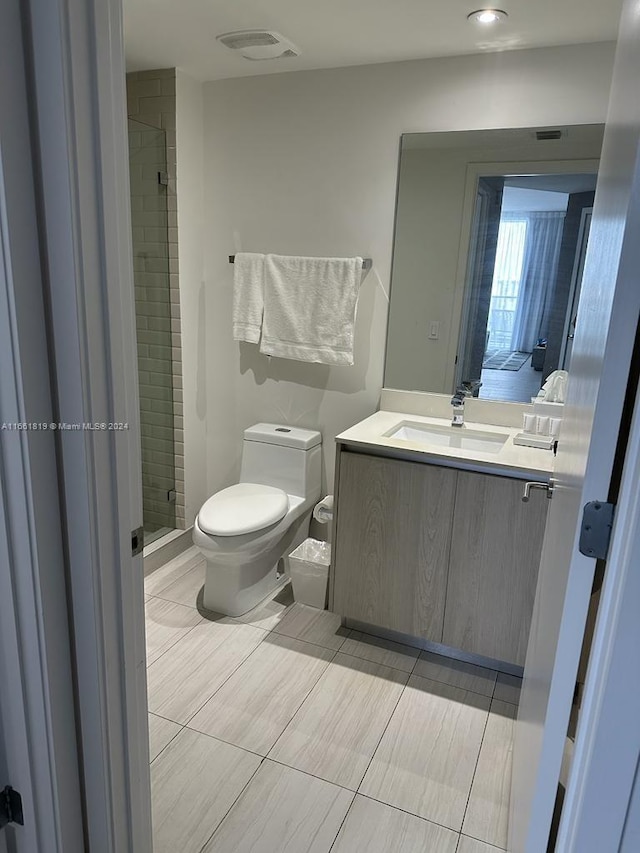 bathroom featuring vanity, toilet, and a shower with door