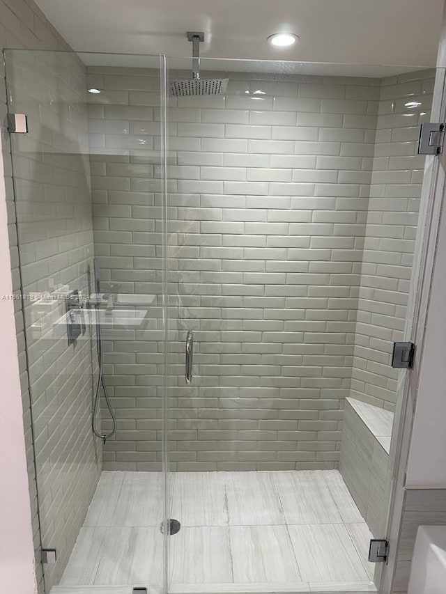 bathroom featuring a shower with door