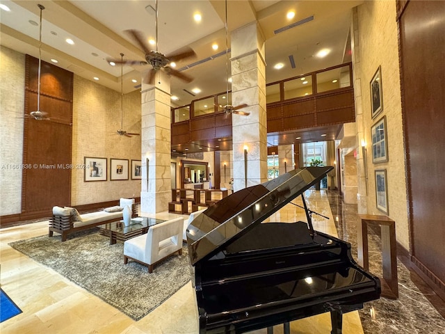 misc room featuring ceiling fan, decorative columns, and a high ceiling