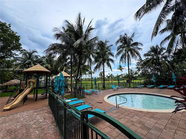 view of swimming pool with a playground