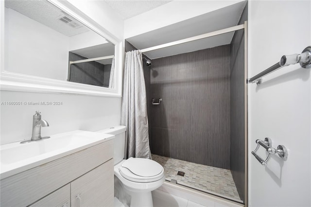 bathroom featuring vanity, toilet, curtained shower, a textured ceiling, and tile patterned flooring