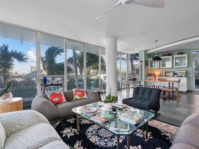 living room with floor to ceiling windows and ceiling fan