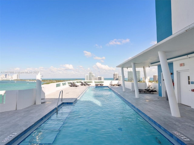 view of pool featuring a patio and a water view