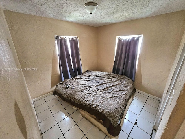 tiled bedroom with a textured ceiling