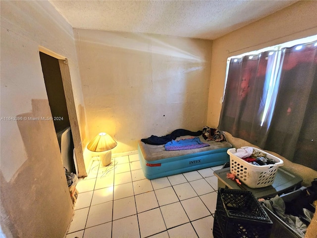 bedroom featuring a textured ceiling and light tile patterned flooring