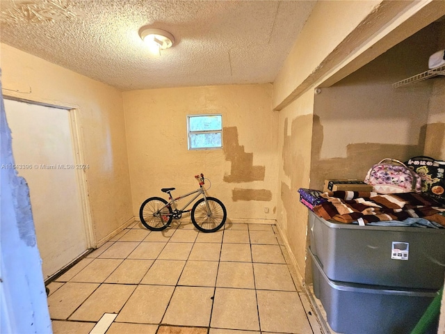 interior space with a textured ceiling and light tile patterned flooring