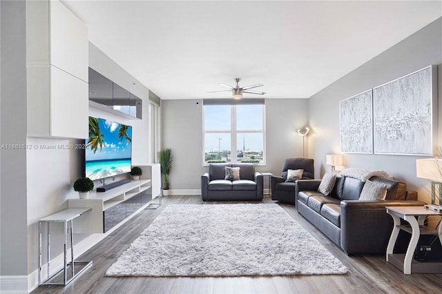 living room with dark wood-type flooring and ceiling fan