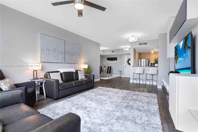 living room featuring dark hardwood / wood-style floors and ceiling fan