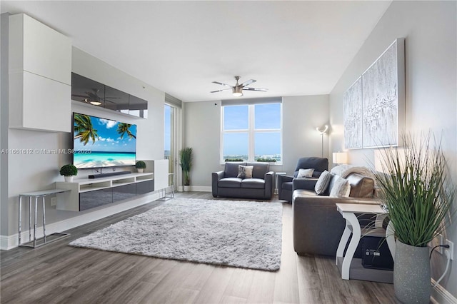 living room featuring ceiling fan and dark wood-type flooring